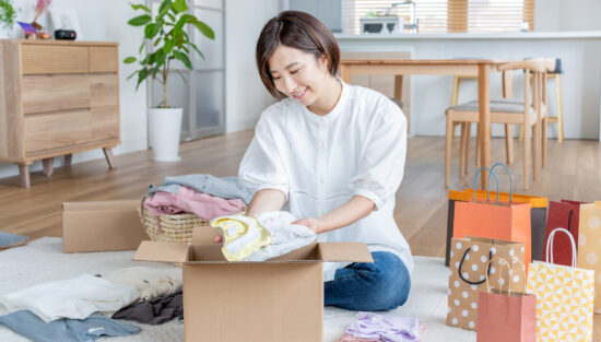 笑顔で引越しの荷造りをする女性