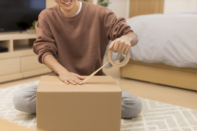 引越し荷物を梱包する男性